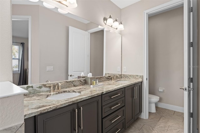 bathroom featuring toilet, dual vanity, and tile flooring