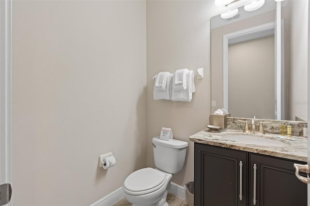 bathroom featuring toilet, vanity with extensive cabinet space, and tile floors