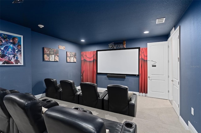 cinema room with light carpet and a textured ceiling