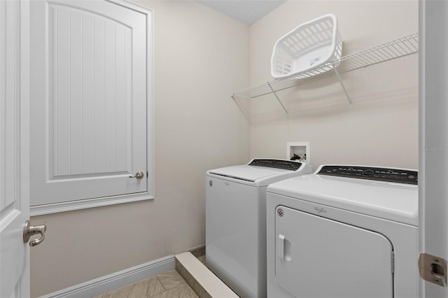 clothes washing area featuring washing machine and clothes dryer, washer hookup, and light tile floors