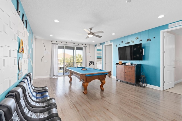 game room featuring billiards, light hardwood / wood-style floors, ceiling fan, and a textured ceiling