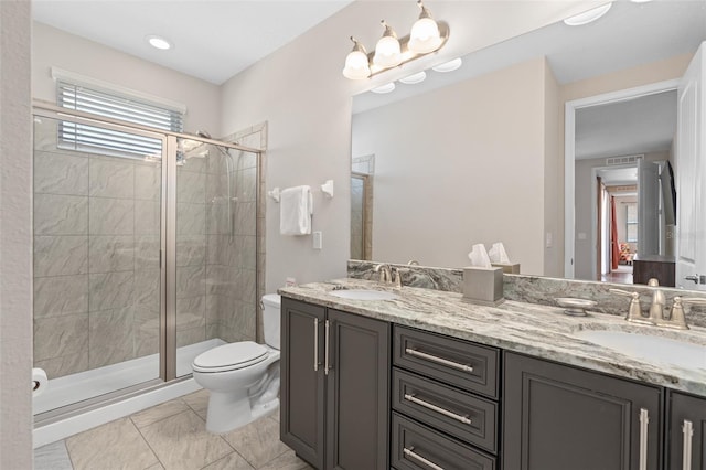 bathroom with double sink, tile floors, a shower with door, toilet, and oversized vanity