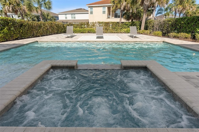 view of pool featuring an in ground hot tub