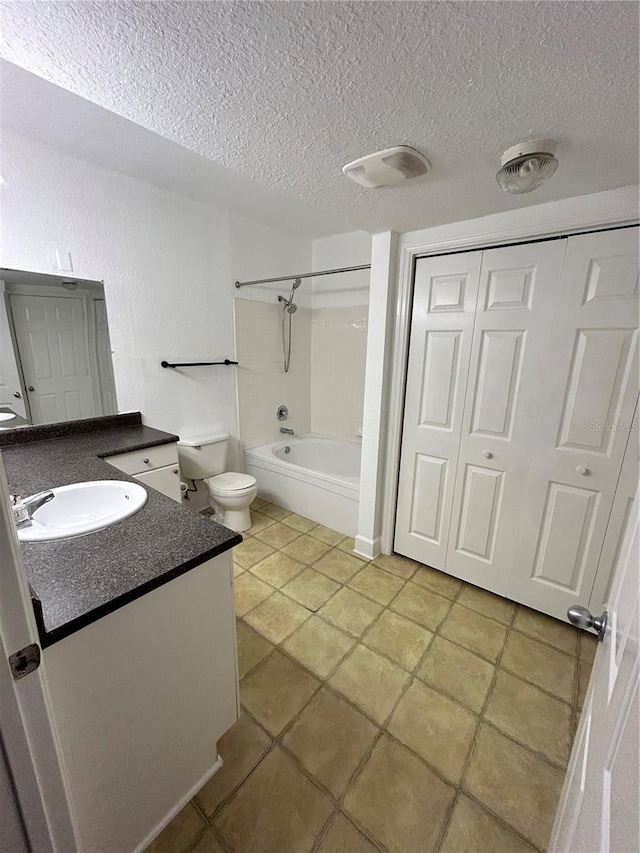 full bathroom with tiled shower / bath combo, tile floors, a textured ceiling, and vanity