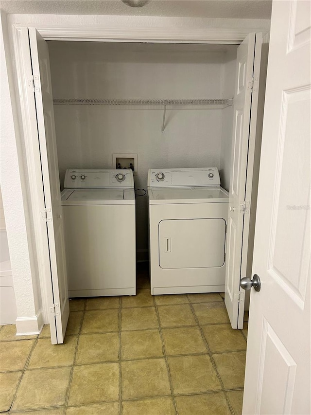 clothes washing area with light tile floors, washer hookup, and independent washer and dryer