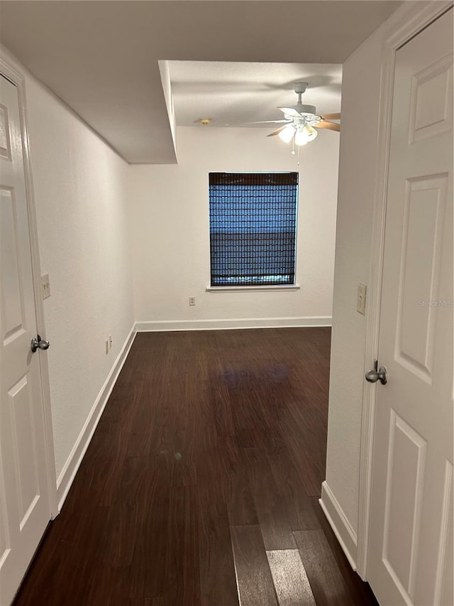 empty room featuring ceiling fan and dark wood-type flooring