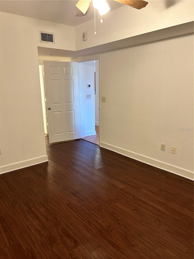 empty room featuring ceiling fan and dark hardwood / wood-style flooring