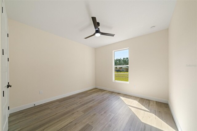 empty room with ceiling fan and light hardwood / wood-style floors