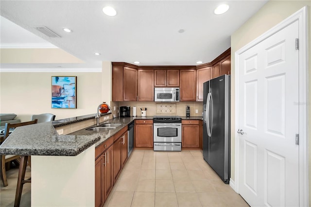 kitchen with kitchen peninsula, sink, a breakfast bar, stainless steel appliances, and light tile flooring