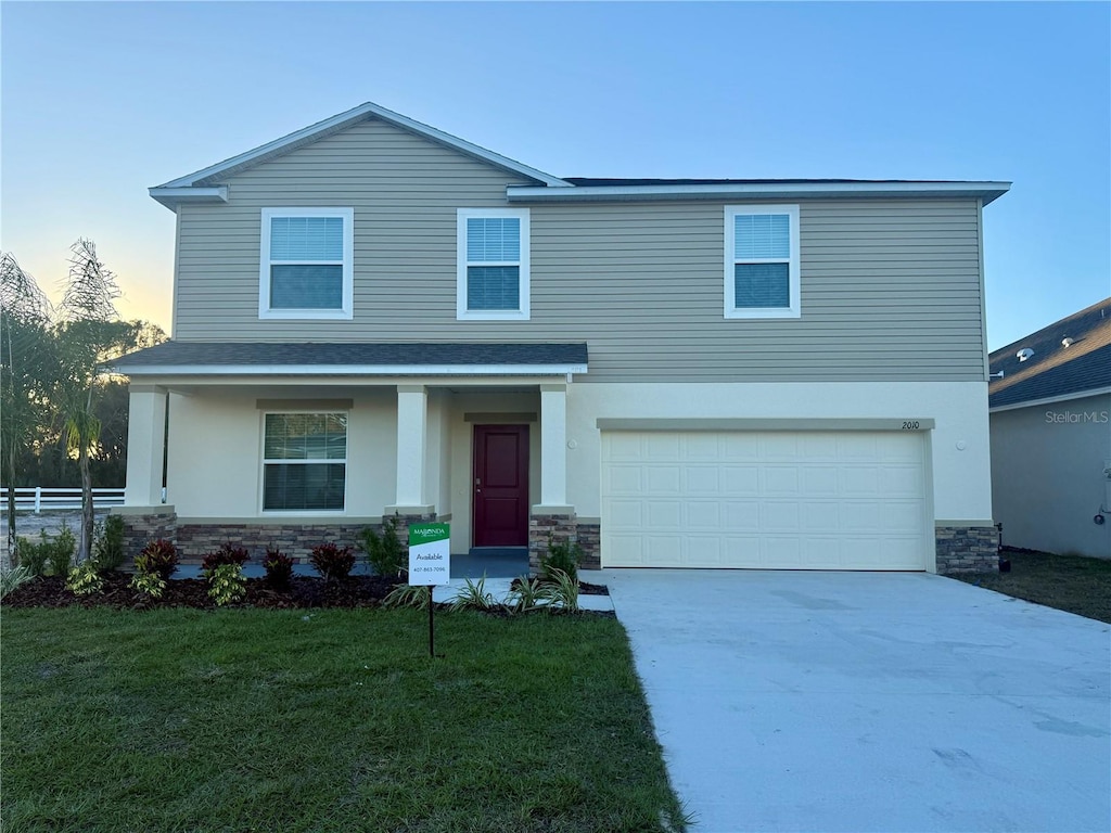 front of property featuring a yard and a garage