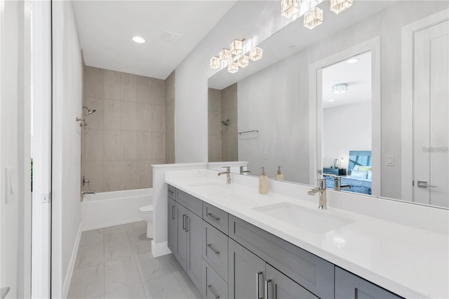 full bathroom with double sink vanity, tile flooring, toilet, and tiled shower / bath