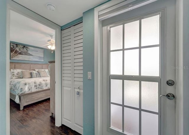 doorway to outside featuring a ceiling fan and dark wood-style flooring