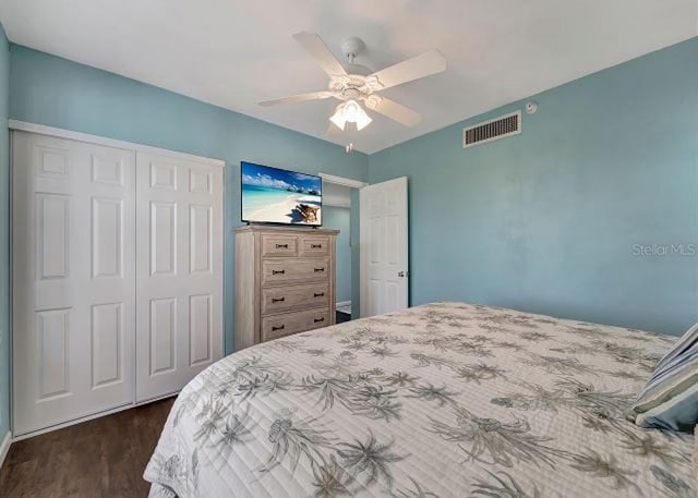 bedroom featuring ceiling fan, a closet, dark wood finished floors, and visible vents