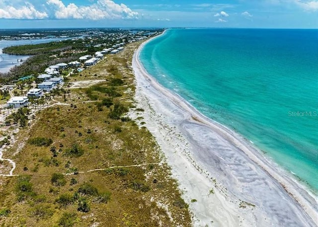 bird's eye view featuring a water view and a beach view