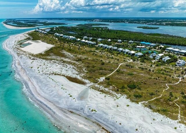 bird's eye view with a water view and a view of the beach