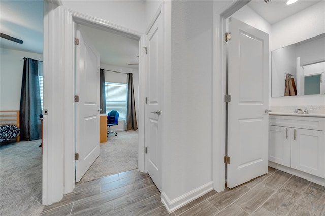 hall with light colored carpet and sink