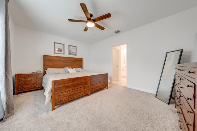 bedroom featuring ensuite bath, light colored carpet, and ceiling fan