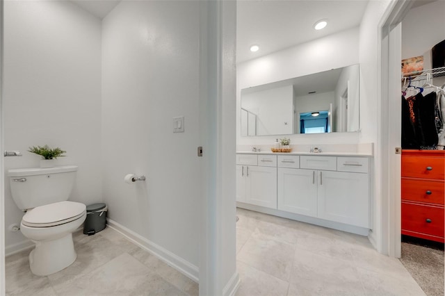 bathroom with toilet, tile floors, and vanity