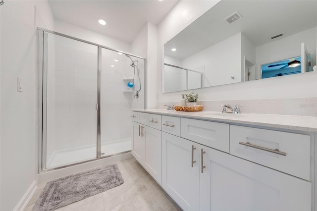 bathroom with tile floors, a shower with shower door, and dual vanity