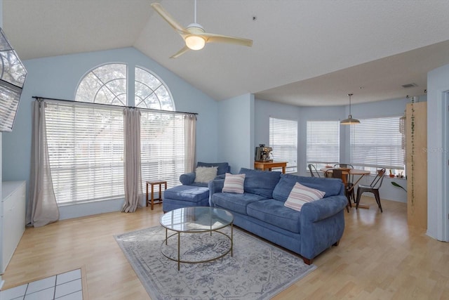 living room with light hardwood / wood-style flooring, ceiling fan, and vaulted ceiling