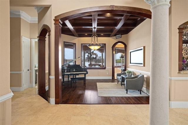 tiled entrance foyer with coffered ceiling, decorative columns, ornamental molding, and beamed ceiling