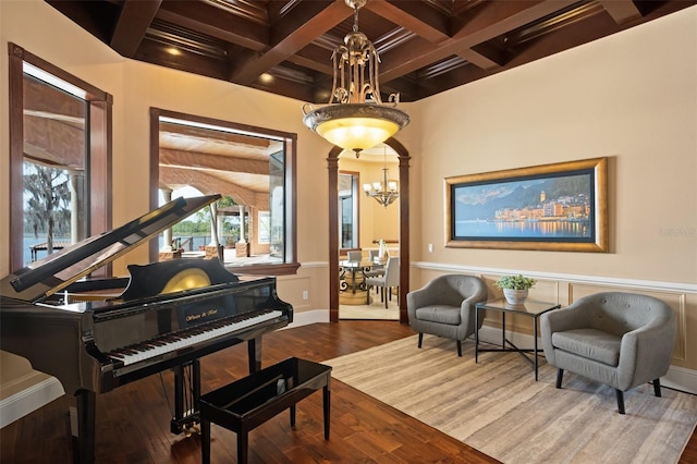 miscellaneous room with beam ceiling, an inviting chandelier, coffered ceiling, and dark wood-type flooring