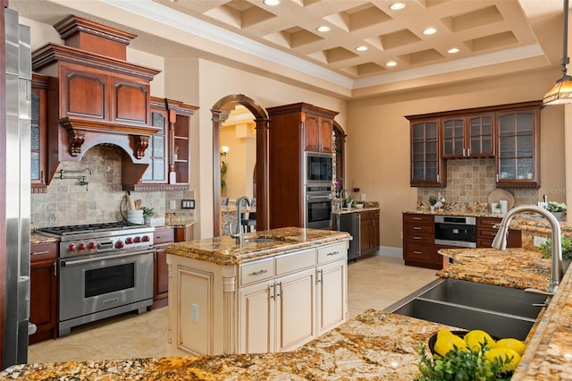 kitchen featuring sink, light tile floors, cream cabinetry, stainless steel appliances, and tasteful backsplash