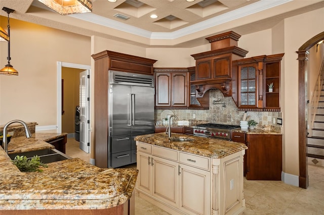 kitchen featuring cream cabinetry, hanging light fixtures, sink, and stainless steel built in fridge