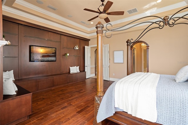 bedroom with ceiling fan, dark hardwood / wood-style floors, a tray ceiling, and ornamental molding