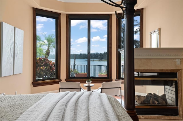 bedroom with a chandelier, a water view, and multiple windows