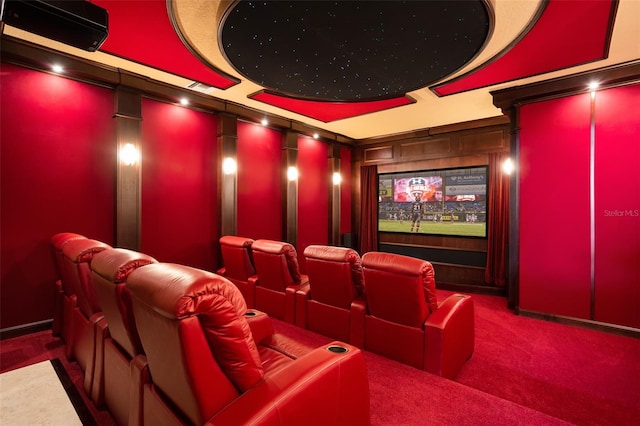 cinema featuring ornate columns, dark colored carpet, and a raised ceiling