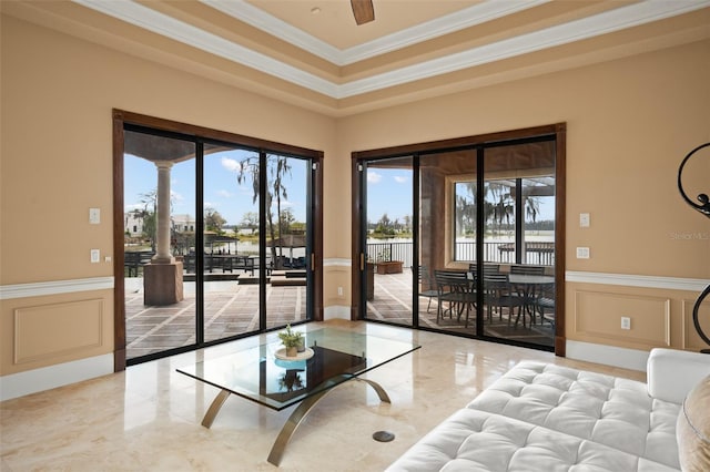 tiled living room with a healthy amount of sunlight, ceiling fan, and crown molding