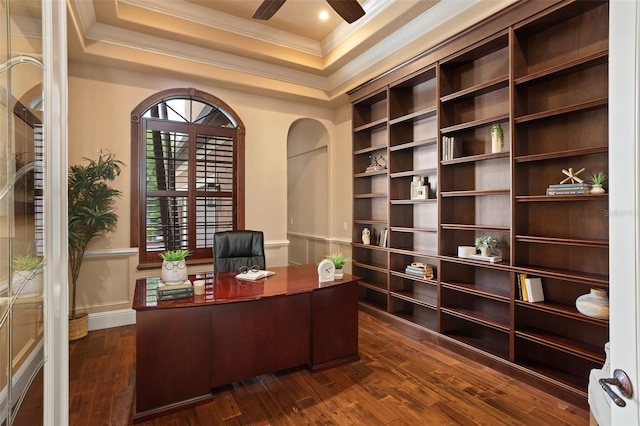 office space with a raised ceiling, dark hardwood / wood-style floors, ceiling fan, and ornamental molding