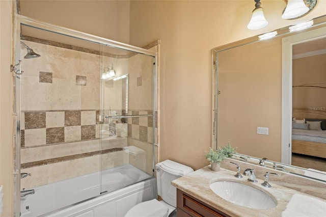 full bathroom featuring toilet, vanity, and bath / shower combo with glass door