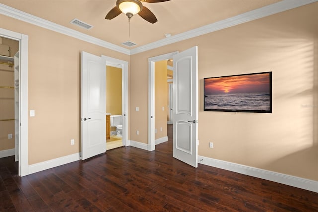 interior space with ensuite bath, ceiling fan, dark wood-type flooring, crown molding, and a spacious closet