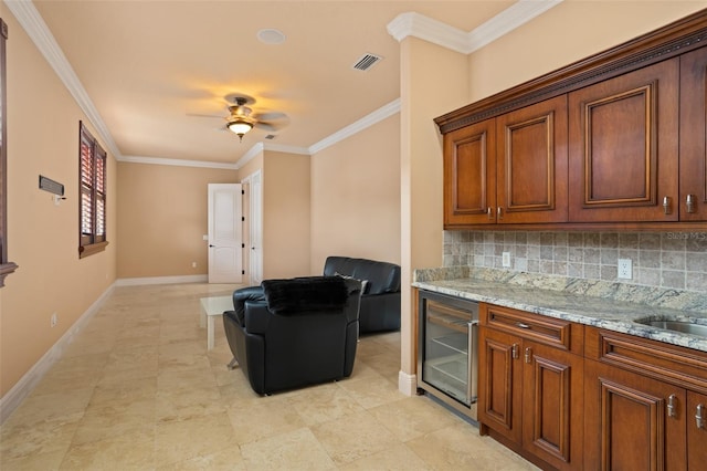 kitchen featuring light stone countertops, ceiling fan, tasteful backsplash, wine cooler, and crown molding