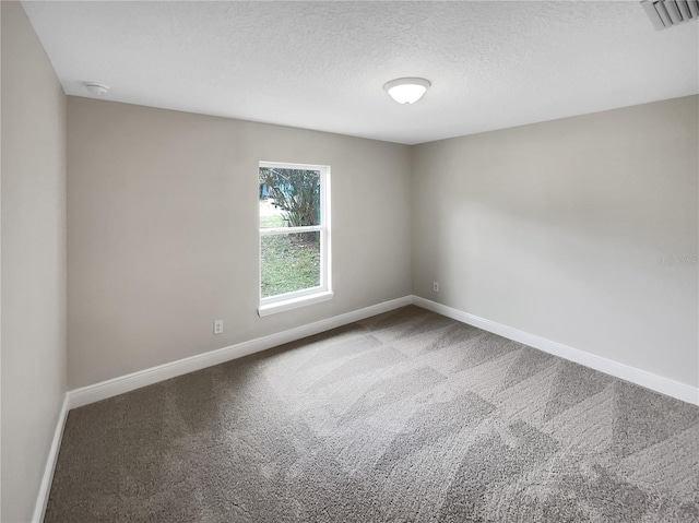 carpeted spare room with a textured ceiling