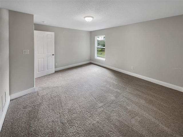 carpeted empty room with a textured ceiling