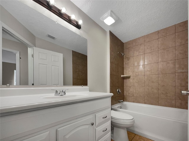 full bathroom with toilet, tiled shower / bath combo, a textured ceiling, vanity with extensive cabinet space, and tile floors