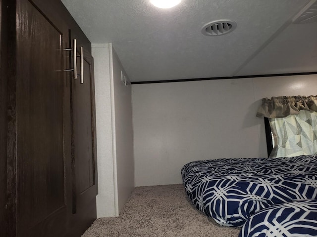 bedroom with light carpet and a textured ceiling