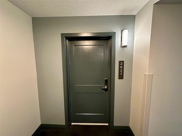 doorway with dark colored carpet