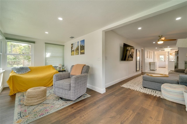 living room with ceiling fan and dark wood-type flooring