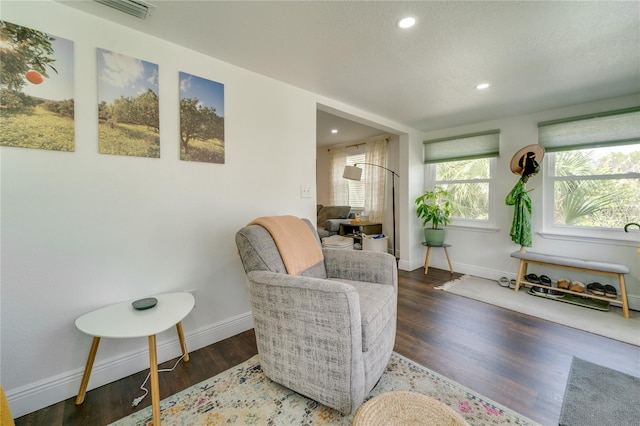 living area with a textured ceiling and dark wood-type flooring