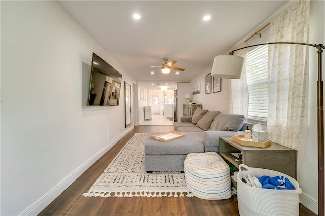 living room with dark hardwood / wood-style floors and ceiling fan