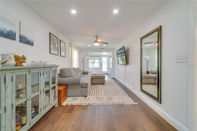 living room with ceiling fan and dark hardwood / wood-style floors