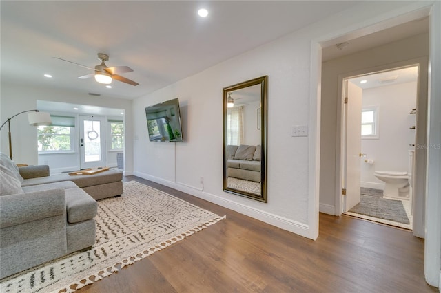 living room featuring a wealth of natural light, ceiling fan, and dark hardwood / wood-style flooring