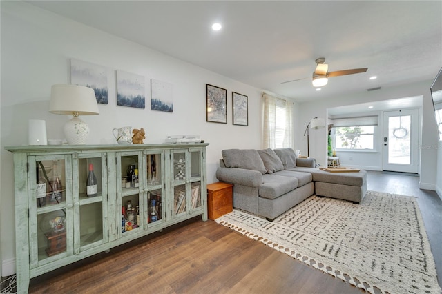 living room with ceiling fan and dark wood-type flooring