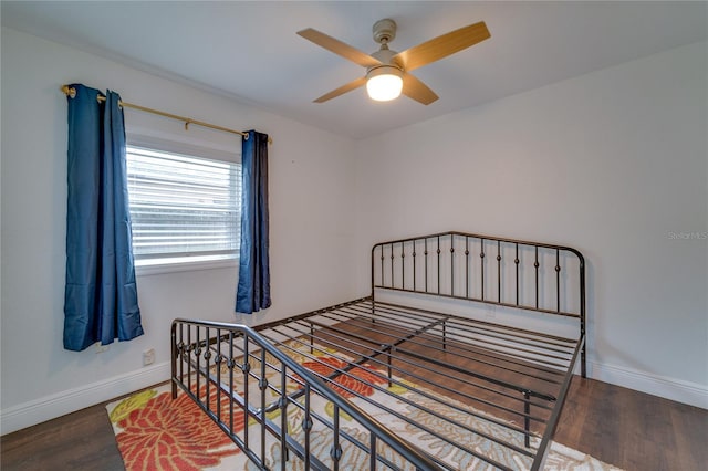 bedroom with dark hardwood / wood-style floors and ceiling fan