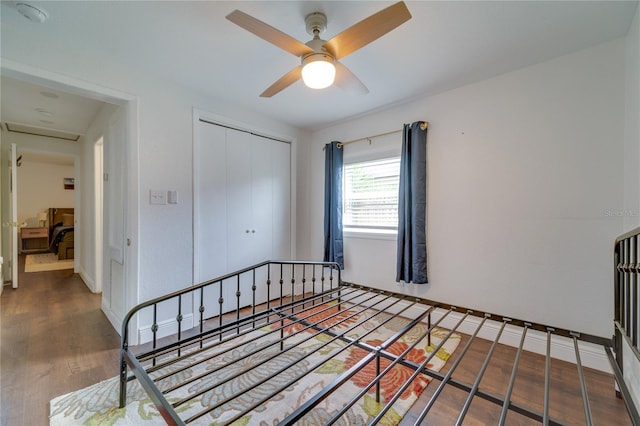 bedroom featuring a closet, dark hardwood / wood-style floors, and ceiling fan