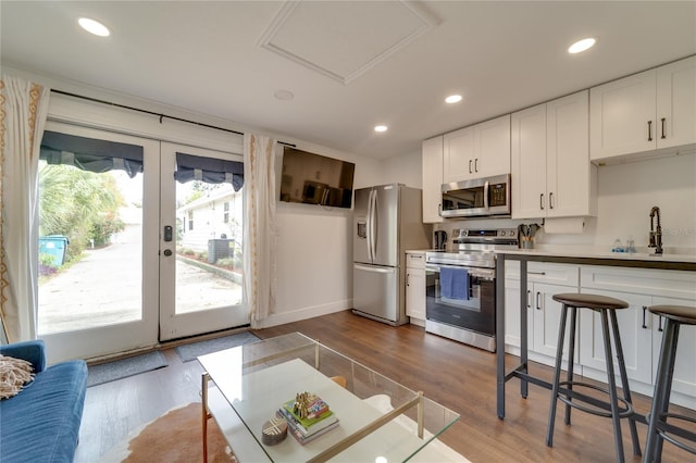 kitchen featuring white cabinets, stainless steel appliances, light hardwood / wood-style flooring, and sink